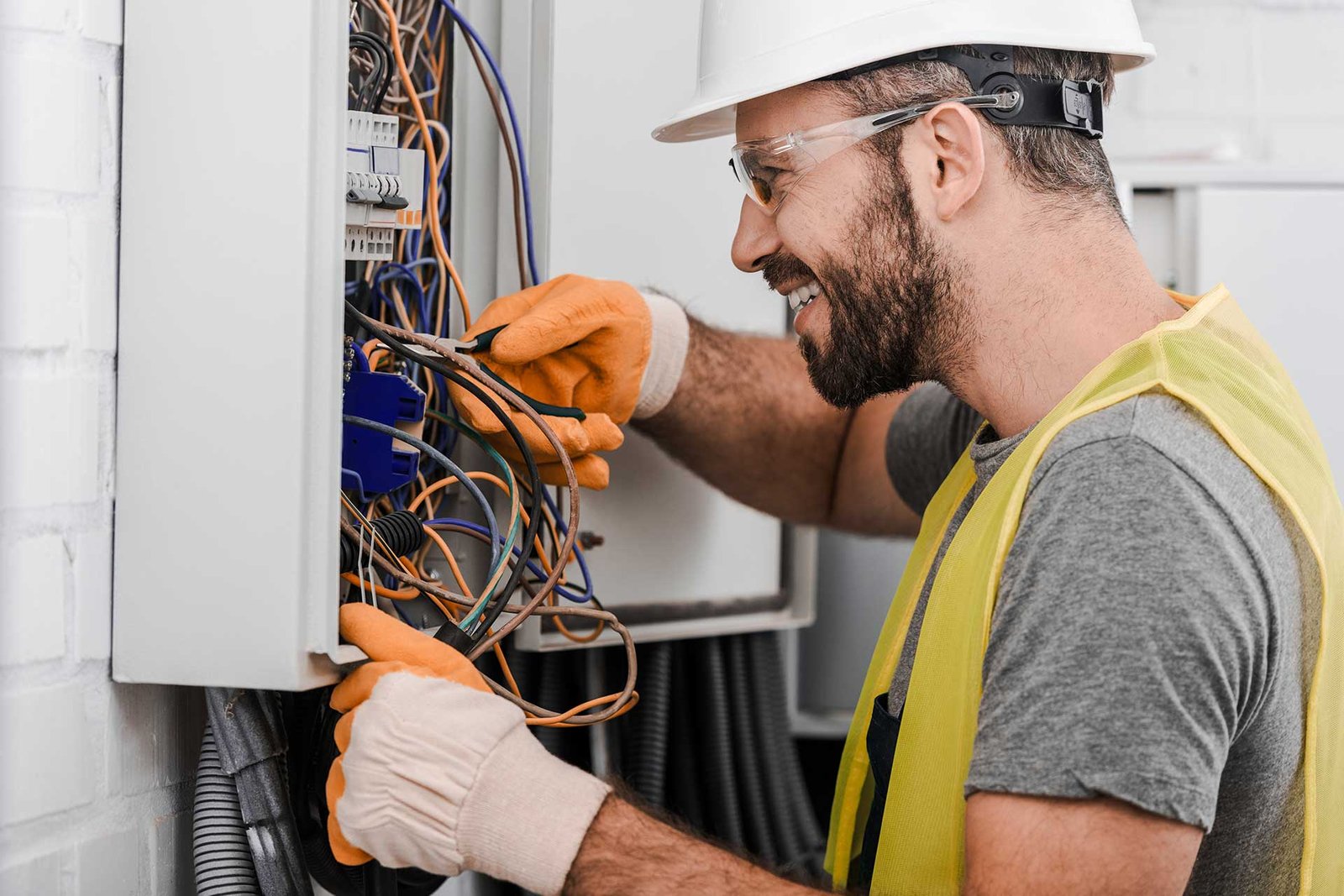 side-view-of-smiling-handsome-electrician-repairin-U2RJJ33.jpg